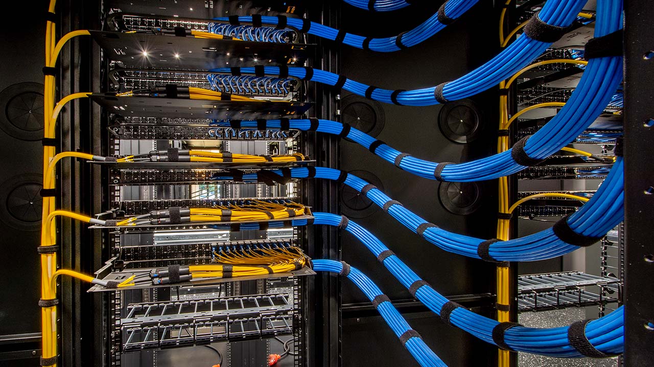 Intricate blue and yellow wiring for an ICT data server room.