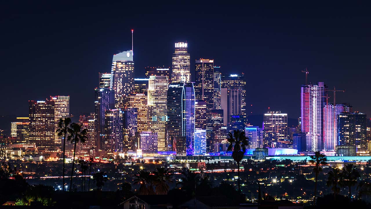 Los Angeles skyline at night. The buildings are brightly lit and almost florescent in some cases.